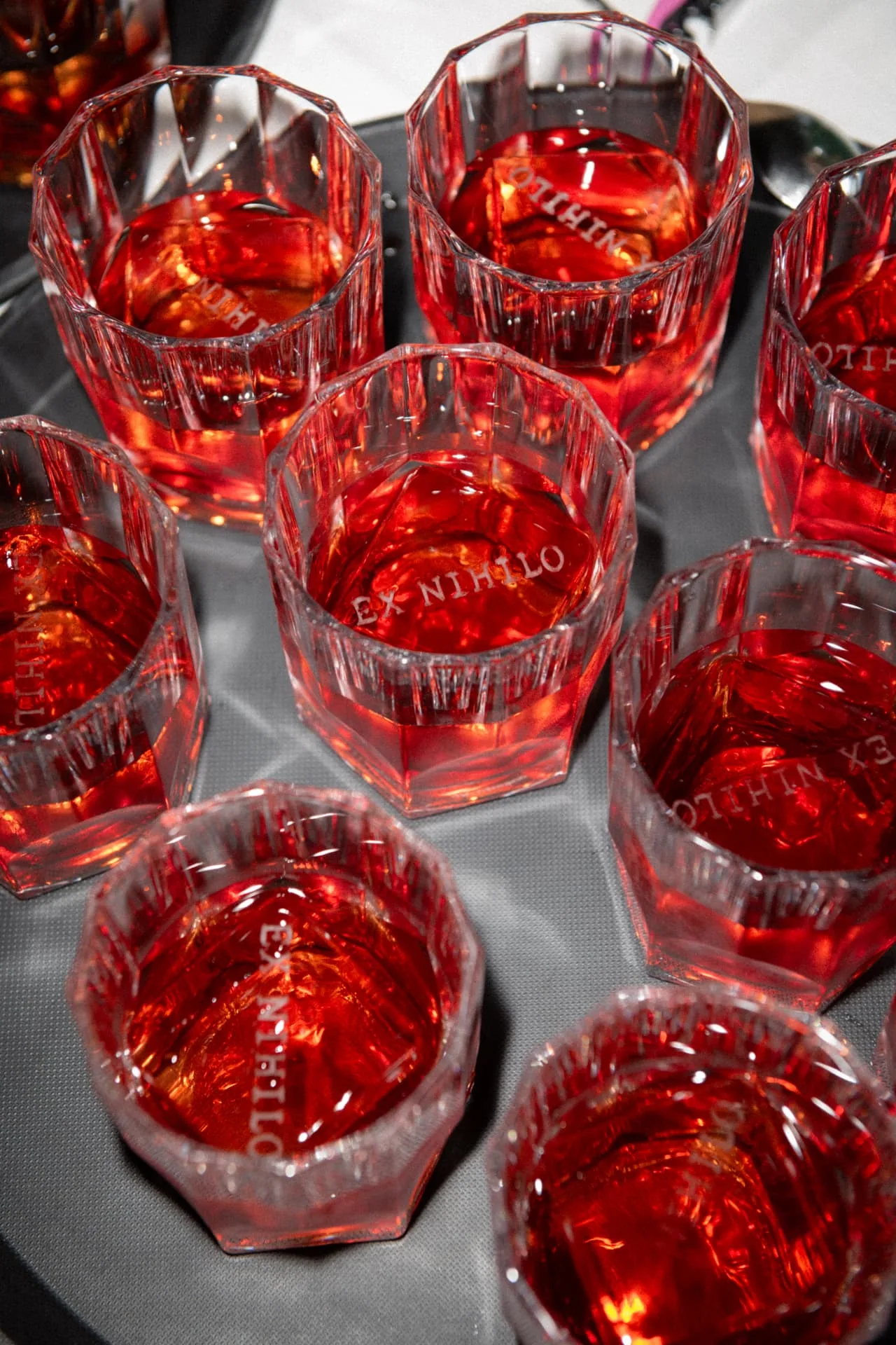 Red EX NIHILO glasses filled with red liquid at the after-dark celebration