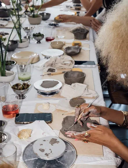Overhead view of the workshop table with clay, tools and drinks