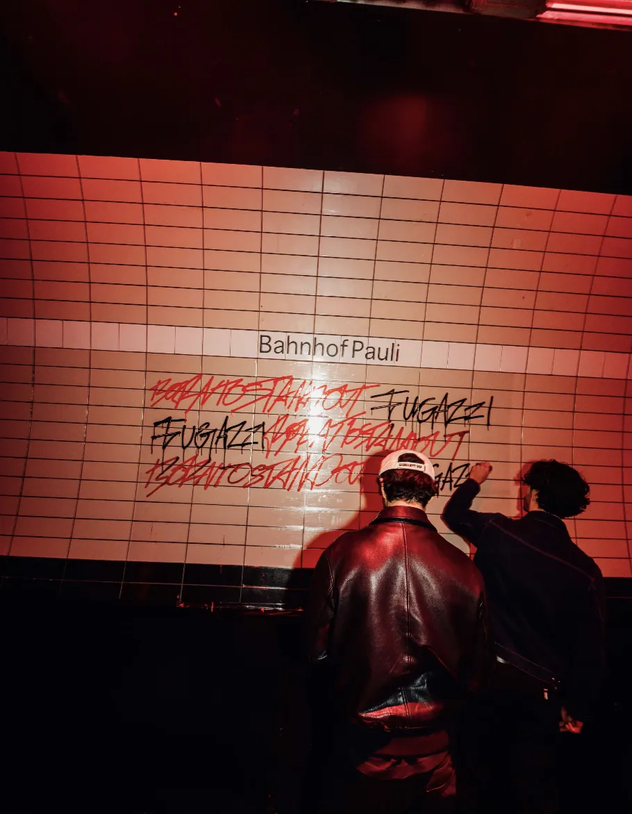 Guests writing on the tiled Bahnhof Pauli campaign wall