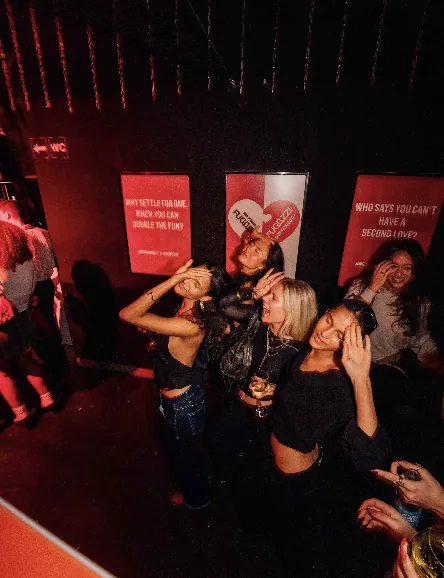 Guests dancing beneath the collaboration campaign posters