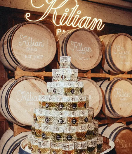 A pyramid of crystal fragrance glasses before Kilian PARIS branded barrels