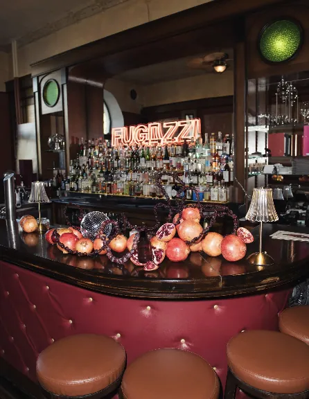 Bar installation with pomegranates, disco balls and the glowing FUGAZZI neon sign