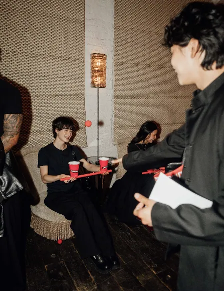 Guests balancing red balls on trays during an interactive game