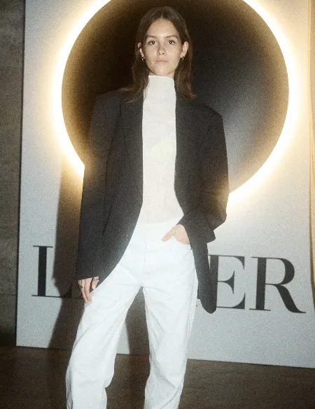 Guest in monochrome tailoring before the illuminated LA MER installation