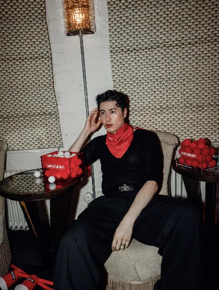 Guest with a red scarf seated among red and white game balls at the BORNTOSTANDOUT launch