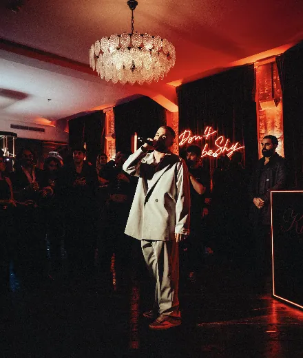 Jamule performing live beneath red lights at the Kilian PARIS event
