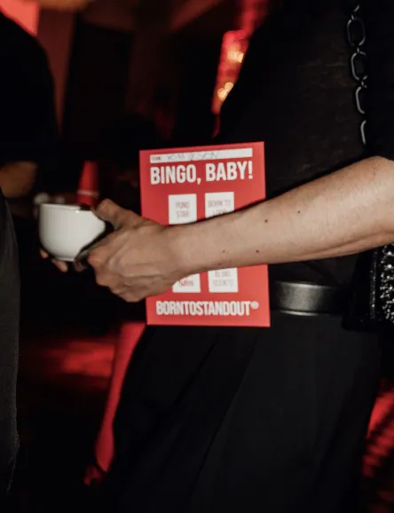 Guest holding a red BINGO, BABY! card at the game night